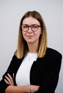 Porträtfoto einer Frau mit langen glatten Haaren und Brille.